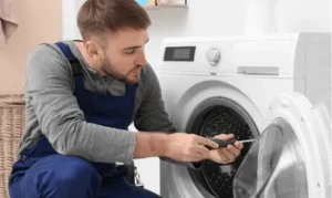 Technician repairing a washing machine in a Dubai home